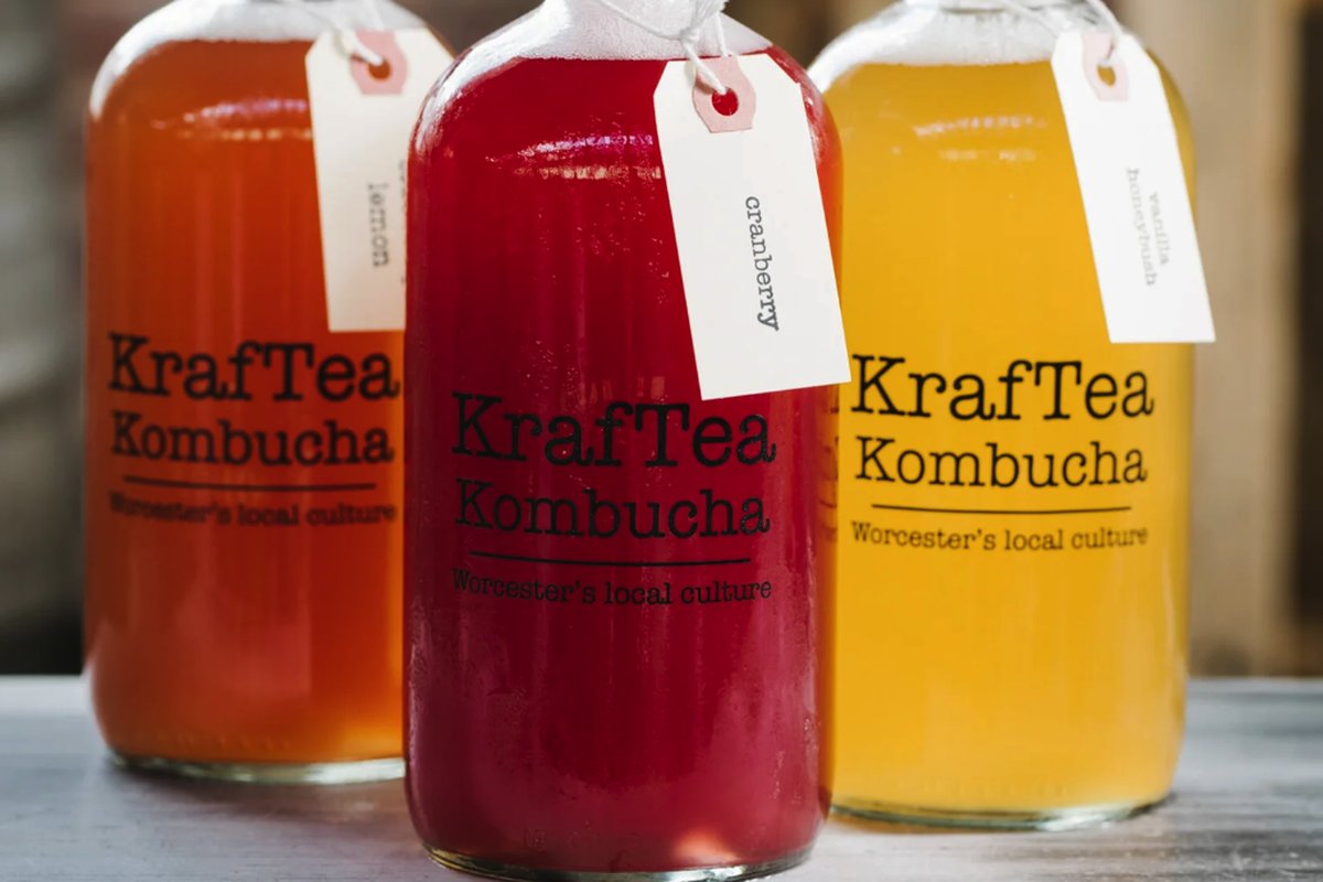 Three bottles of KrafTea Kombucha in lemon, cranberry, and vanilla flavors