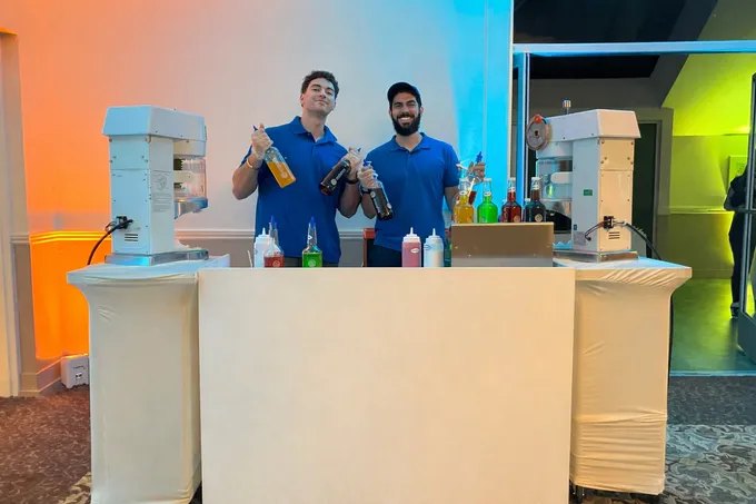 The Tropics Shave Ice team behind their shave ice bar at an indoor event