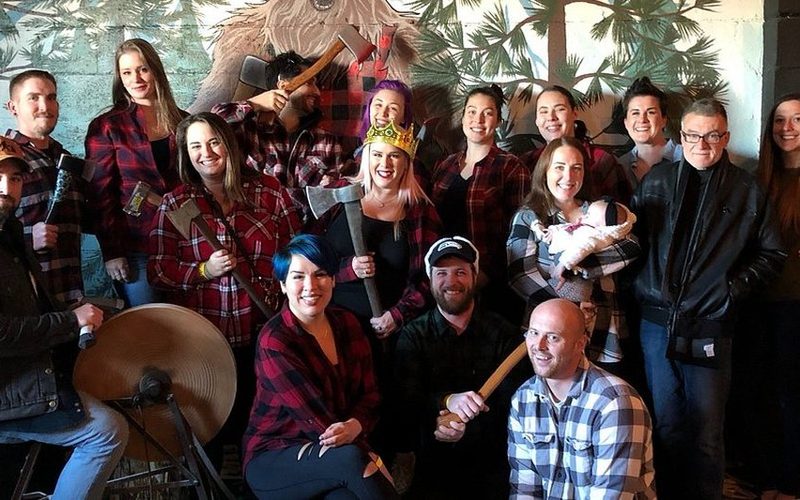 A corporate group posing with axes at Axe Kickers
