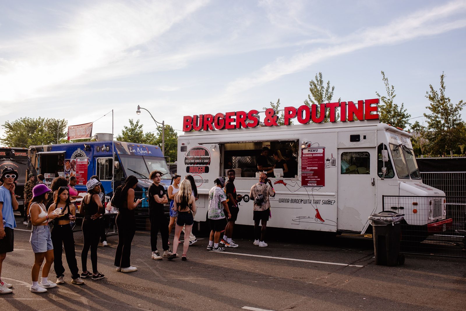Long line of people queuing at a food truck at an outdoor event