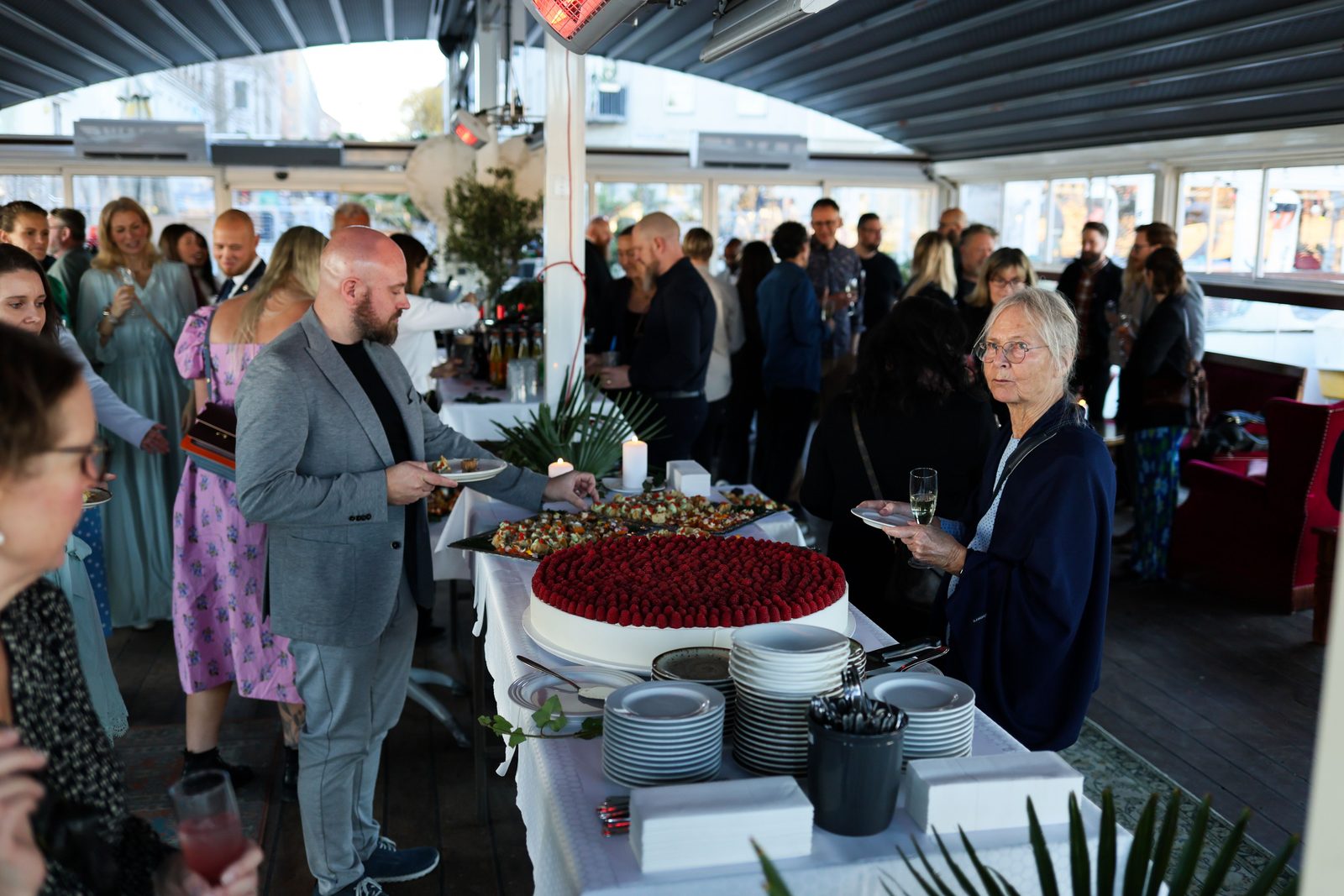 Guests mingling with drinks at an event in a large modern venue